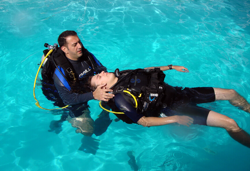 An unresponsive diver being towed in a pool.